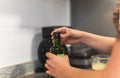 Hands opening a bottle cap of oil or some ingredient in the kitchen