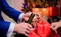 Hands opening champagne bottle and hold glass christmas decorations background. Cheers concept. Last minute before new Royalty Free Stock Photo