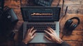 Hands operate a laptop displaying audio editing software with visible waveforms