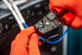 Hands in orange insulating gloves work with crimping pliers and cables. Horizontal orientation. Royalty Free Stock Photo