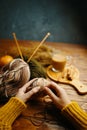 Hands in orange sweater with yarn, knitting needles and coffee. Royalty Free Stock Photo