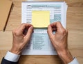 Hands Organizing Financial Documents with Sticky Note on Desk Royalty Free Stock Photo