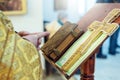 The hands of an Orthodox priest, a cross and a prayer book.