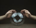 hands over transparent glass ball