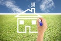 Hands are painted house on grass and blue sky. Royalty Free Stock Photo