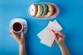 Hands painting heart with tea and donuts Royalty Free Stock Photo