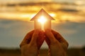 Hands with paper prayer house in the hands . Royalty Free Stock Photo