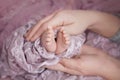 Hands of parents of dad and mom are holding in their hands the legs of a newborn baby Royalty Free Stock Photo