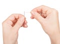 Hands passing a thread in a needle