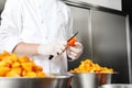 hands pastry chef cutting apricots, prepare the jam in industrial kitchen