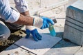 Hands of a pavement construction worker installing tiles with a rubber hammer Royalty Free Stock Photo