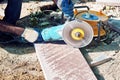 Hands of a pavement construction worker using an angle grinder for cutting the tiles Royalty Free Stock Photo