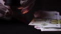 Hands of a pawnshop owner who is appraising gold ring by magnifying glass in close-up