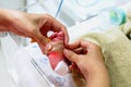 Hands of pediatric nurse using medical adhesive plaster stick and strap to measure oxygen in the blood