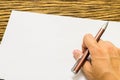 Hands with pen over paper on wooden background