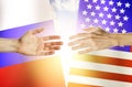 Hands people against the backdrop flags Russia and USA