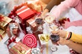 Hands of people celebrating New year party in home with wine drinking glasses and present background. New year and Christmas part Royalty Free Stock Photo