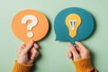 In the hands of people, conversational clouds with a question mark and a light bulb represent the pursuit of solutions Royalty Free Stock Photo