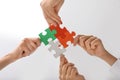 Hands of people with jigsaw puzzle pieces, bottom view