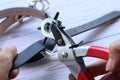 Hands of people punching hole of belt leather using the Metal hole puncher