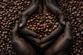 hands of people showing a pile of roasted coffee beans in front of a background composed of many other coffee beans Royalty Free Stock Photo