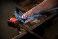 Hands of a person glass blowing in the workshop