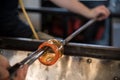 Hands of a person glass blowing in the workshop