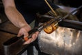 Hands of a person glass blowing in the workshop