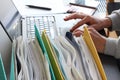 Hands of person typing on laptop computer with binders filled with papers in foreground. Selective focus Royalty Free Stock Photo