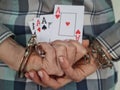 Hands of persons in handcuffs holds poker playing cards Royalty Free Stock Photo