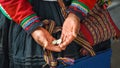 Close up of weaving and culture in Peru. Cusco, Peru: woman dressed in colorful traditional native Peruvian closing holding