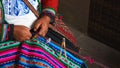 Close up of weaving in Peru. Cusco, Peru. Woman dressed in colorful traditional native Peruvian closing knitting a carpet with Royalty Free Stock Photo