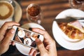 Hands with phone. Breakfast for two: a croissant with ham, coffee, a refreshing drink