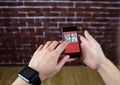hands with phone in front of a brick wall. In the phone the design of the new wall.