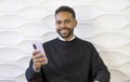 Hands, phone and social media with a black man typing a text message while sitting on a sofa in his home. Mobile, communication. Royalty Free Stock Photo