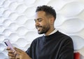 Hands, phone and social media with a black man typing a text message while sitting on a sofa in his home. Mobile, communication. Royalty Free Stock Photo