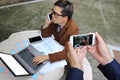 Hands of photographer taking a photo of handsome young business man while talking on the phone with his smartphone.