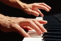 Hands of pianist play the keys of the piano on black background close up Royalty Free Stock Photo