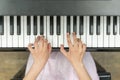 Hands on piano keys close-up. Closeup girl's hand playing piano. Favorite classical music. Top view with dark vignette. View from Royalty Free Stock Photo