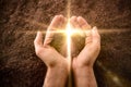 Hands with a pile of dirt with a cross-shaped flash Royalty Free Stock Photo