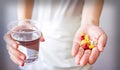 Hands with pills and glass of water isolated on white Royalty Free Stock Photo