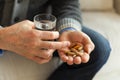 Hands with pills. Senior man hands holding medical pill and glass of water. Mature old senior grandfather taking Royalty Free Stock Photo