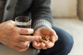 Hands with pills. Senior man hands holding medical pill and glass of water. Mature old senior grandfather taking Royalty Free Stock Photo