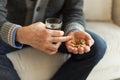 Hands with pills. Senior man hands holding medical pill and glass of water. Mature old senior grandfather taking Royalty Free Stock Photo