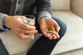 Hands with pills. Senior man hands holding medical pill and glass of water. Mature old senior grandfather taking Royalty Free Stock Photo