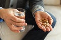 Hands with pills. Senior man hands holding medical pill and glass of water. Mature old senior grandfather taking Royalty Free Stock Photo