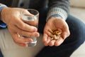 Hands with pills. Senior man hands holding medical pill and glass of water. Mature old senior grandfather taking Royalty Free Stock Photo