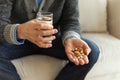 Hands with pills. Senior man hands holding medical pill and glass of water. Mature old senior grandfather taking Royalty Free Stock Photo
