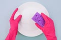 Hands in pink protective gloves washing a plate Royalty Free Stock Photo
