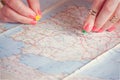 Hands pinning travel destination points on map, filtered